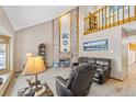 Inviting living room with soaring ceilings, brick fireplace, and natural light at 7624 S Cove Cir, Centennial, CO 80122