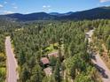 Stunning aerial view of a secluded home amidst a dense forest and winding roads at 8422 S Ault Ln, Morrison, CO 80465