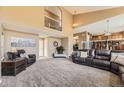 Open-concept living area with two-story ceilings and neutral carpet at 6186 S Millbrook Way, Aurora, CO 80016