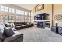 Spacious living room featuring high ceilings, large windows, and a cozy fireplace at 6186 S Millbrook Way, Aurora, CO 80016