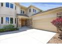 Front exterior showcasing stone accents, a large garage door, and manicured landscaping at 13950 E Chenango Dr, Aurora, CO 80015