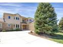 Exterior view of the two-story home with a manicured lawn, large tree, and concrete driveway at 13950 E Chenango Dr, Aurora, CO 80015