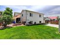 Spacious backyard with lush green grass and a patio area perfect for entertaining at 11883 W Marlowe Pl, Morrison, CO 80465