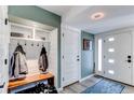 Mudroom features a built-in bench, shelving, and coat hooks, with easy access to front door at 2823 S Xanadu Way, Aurora, CO 80014