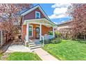 Charming home with a brick exterior, a cozy front porch, and a well-maintained lawn at 3513 Quitman St, Denver, CO 80212