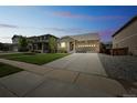 Exterior view of home at twilight with a long driveway and landscaped yard with neighbors on either side at 1261 W 170Th Ave, Broomfield, CO 80023
