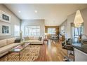 Spacious living room featuring hardwood floors, a comfortable white couch, large windows, and adjacent dining area at 1261 W 170Th Ave, Broomfield, CO 80023