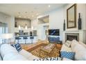 Open-concept living area with hardwood floors, fireplace, vaulted ceiling, and kitchen with an island and bar seating at 1261 W 170Th Ave, Broomfield, CO 80023