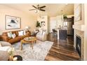 Open-concept living space with modern furniture, a kitchen island, and a cozy fireplace at 5562 W 72Nd Pl, Westminster, CO 80003