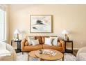 Cozy living room featuring a leather sofa, stylish decor, and ample natural light at 5562 W 72Nd Pl, Westminster, CO 80003