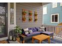 Inviting front porch featuring outdoor seating, potted plants, and stylish decor with a modern aesthetic at 15960 W 62Nd Dr, Arvada, CO 80403