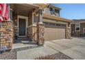 Close up of the front entrance showcasing stone pillar accents and a modern two car garage at 9574 Keystone Trl, Parker, CO 80134