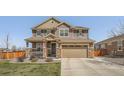 Charming two-story home with a manicured lawn, a covered porch, and an attached two-car garage at 9574 Keystone Trl, Parker, CO 80134