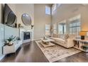 Spacious living room featuring high ceilings, large windows, hardwood floors, and a fireplace at 9574 Keystone Trl, Parker, CO 80134