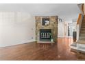 Open living room featuring a stone fireplace, hardwood floors and staircase at 10814 Bayfield Way, Parker, CO 80138