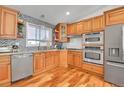 Updated kitchen with stainless steel appliances, granite countertops, herringbone backsplash, and wooden cabinets at 5183 Durham Ct, Denver, CO 80239