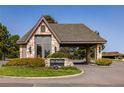 Community entrance featuring a stone building with a porte cochere and lush landscaping for a welcoming feel at 9 Roder Gate Ln, Castle Pines, CO 80108