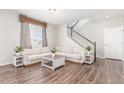 Bright living room features hardwood floors, a plush sofa and staircase leading to the upper level at 22921 E Union Ave, Aurora, CO 80015