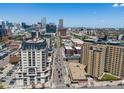 A clear street view captures the building's facade, with the Denver skyline in the distance and bustling city life at 975 N Lincoln St # 3H, Denver, CO 80203