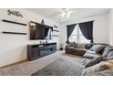 Cozy living area with fireplace, mounted TV, and comfortable sectional seating at 178 Blue Bonnet Dr, Brighton, CO 80601