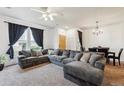 Bright living room features plush sectional sofa, large windows, and stylish lighting at 178 Blue Bonnet Dr, Brighton, CO 80601