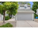 Charming two-story home with gray siding, attached garage, and landscaped front yard at 12717 E Cornell Ave, Aurora, CO 80014