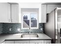 The kitchen features stainless steel appliances, a tile backsplash and plenty of natural light at 5250 S Huron Way # 13-312, Littleton, CO 80120
