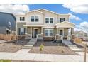 Inviting townhome exterior featuring modern architecture with stone accents and landscaped front yard at 13458 E 111Th Ave, Commerce City, CO 80022