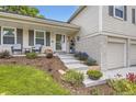 Inviting front porch featuring charming chairs, complemented by meticulously maintained landscaping and a brick-accented facade at 7465 S Ivy Way, Centennial, CO 80112