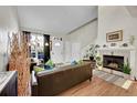 Inviting living room featuring hardwood floors, a cozy fireplace, and plenty of natural light at 8371 S Upham Way # 208, Littleton, CO 80128