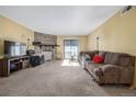 Bright living room featuring a stone fireplace, sliding glass door and neutral décor offering a cozy ambiance at 8335 Fairmount Dr # 4-102, Denver, CO 80247