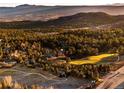 Aerial shot showcasing the property's location surrounded by lush greenery and a golf course at 7332 Woodglen Pl, Castle Pines, CO 80108