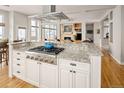 Open kitchen with granite countertops, a stainless steel range hood, and adjacent living spaces at 7332 Woodglen Pl, Castle Pines, CO 80108