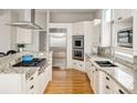 Bright kitchen featuring granite counters, stainless steel appliances, and hardwood floors at 7332 Woodglen Pl, Castle Pines, CO 80108