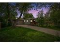 Charming single-story home with well-maintained lawn, driveway, garage and inviting front porch at dusk at 4285 Newland St, Wheat Ridge, CO 80033