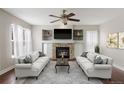 Bright living room featuring a stone fireplace, built-in shelving, and comfortable sofas at 10532 Wintersweet Ct, Parker, CO 80134