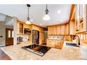 Well-appointed kitchen featuring granite countertops, stainless steel appliances, and custom wood cabinetry at 8788 E Tanglewood Rd, Franktown, CO 80116