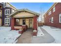 Brick bungalow home exterior, snowy front yard, walkway at 4234 N Raleigh St, Denver, CO 80212