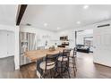 Bright kitchen features stainless steel appliances, white cabinets, an island with barstool seating, and hardwood floors at 1742 S Alcott St, Denver, CO 80219