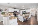 Bright kitchen features white cabinets, granite countertops, stainless appliances and an island with seating at 13340 Saint Paul St, Thornton, CO 80241