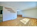 Bright living room with hardwood floors, floating shelves, and a glimpse of the adjoining room at 1209 S Terry St, Longmont, CO 80501