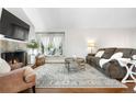A spacious living room that features a cozy fireplace, ample seating, and natural light at 6700 W 80Th Cir, Arvada, CO 80003