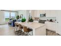 Modern kitchen featuring white cabinetry, quartz countertops, and an island at 565 Twilight St, Erie, CO 80516