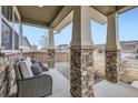 Inviting covered front porch with brick columns and comfortable seating area at 1853 Griffin Dr, Brighton, CO 80601