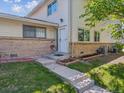 Inviting entrance with flower bed and well-manicured lawn leading to the front door at 3351 S Field St, Lakewood, CO 80227