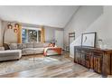 Inviting living room with vaulted ceiling, large window, modern light fixture, and stylish decor at 1244 S Reed St # 2, Lakewood, CO 80232