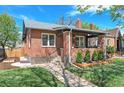 Charming brick home with manicured lawn, covered porch, and lovely landscaping at 1939 S Sherman St, Denver, CO 80210