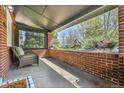 Relaxing covered porch featuring a brick accent wall, comfortable chair, and colorful flowers, perfect for outdoor enjoyment at 1939 S Sherman St, Denver, CO 80210