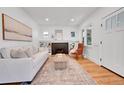Bright living room with a cozy fireplace, large windows, hardwood floors, and neutral-toned furniture for relaxed living at 1939 S Sherman St, Denver, CO 80210