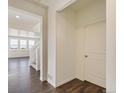 Bright entryway featuring hardwood floors, an interior door, and a view to the stairs and living area at 9882 Cathay St, Commerce City, CO 80022
